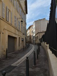 Empty road amidst buildings in city