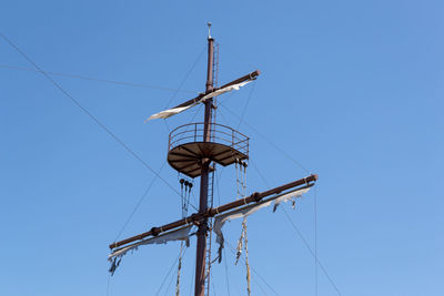 Low angle view of old boat pylon against clear blue sky