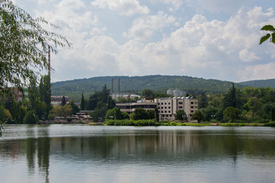 Lake by buildings against sky