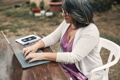 Camping woman using laptop sitting at table