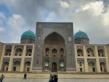 Facade of historical building against cloudy sky