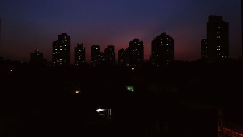 Illuminated cityscape against sky at night