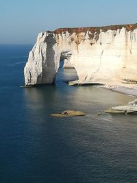 Scenic view of rock formation in sea against sky