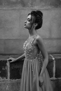 Young woman standing against wall