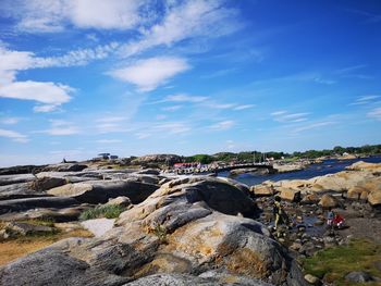 People on rock formations against sky