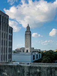 Buildings in city against cloudy sky