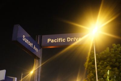 Low angle view of illuminated information sign at night