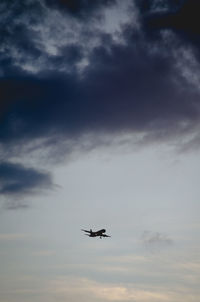 Low angle view of silhouette airplane against sky during sunset