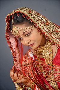 Beautiful young bride standing against wall