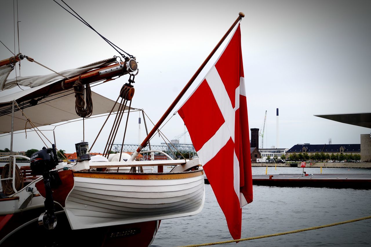 flag, transportation, nautical vessel, patriotism, mode of transport, identity, national flag, american flag, sky, boat, sea, red, men, travel, clear sky, incidental people, leisure activity, mast, lifestyles