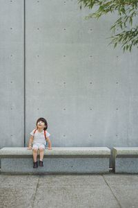 Portrait of boy standing against wall