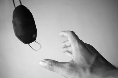 Close-up of hand holding paper over white background