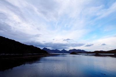 Scenic view of lake by mountains against sky