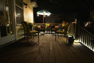 Furniture at illuminated patio during night