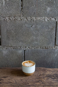 Close-up of coffee on table against wall