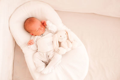 High angle view of baby girl sleeping with stuffed animal at home