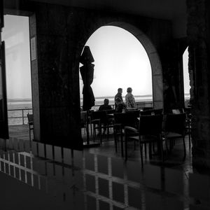 Silhouette people sitting in front of building