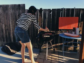 Rear view of woman standing on chair