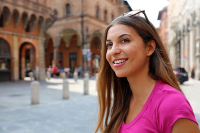 Portrait of smiling young woman in city