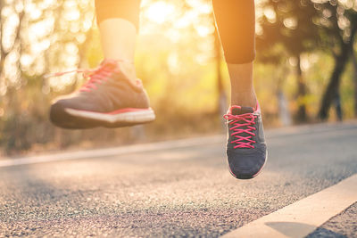 Low section of woman jumping over road