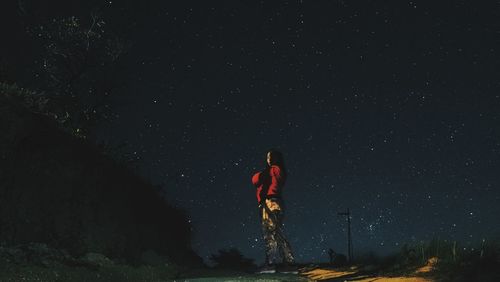 Man standing on mountain against sky at night