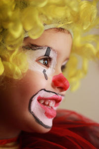 Little girl dressed as a clown with blonde wig profile portrait photo