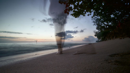 Blurred motion of man on beach against sky