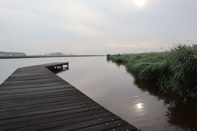 Scenic view of pier over lake against sky