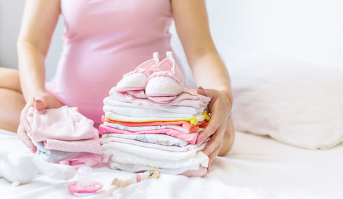 Pregnant woman folding clothes at home