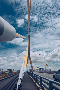 View of suspension bridge against cloudy sky