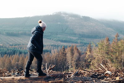 Full length of woman standing by tree on mountain