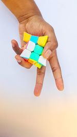 Close-up of hand holding toy against sky