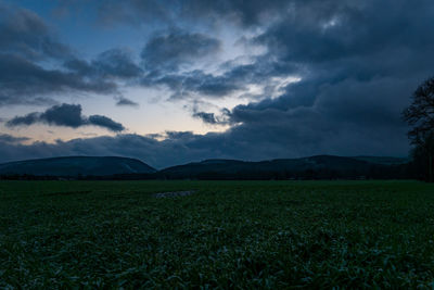 Scenic view of field against cloudy sky