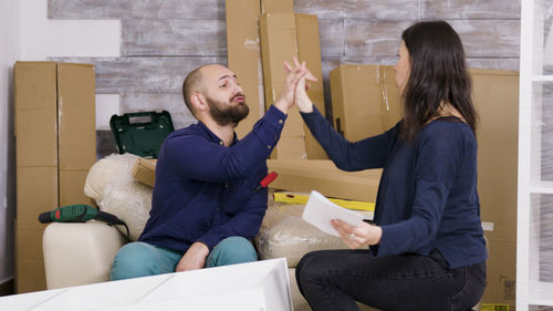 Side view of couple sitting on sofa at home