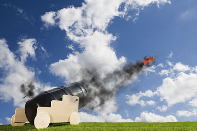 Smoke stack on field against sky