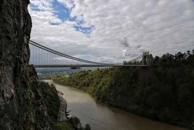 Bridge over river against cloudy sky