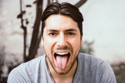 Portrait of young man sticking out tongue