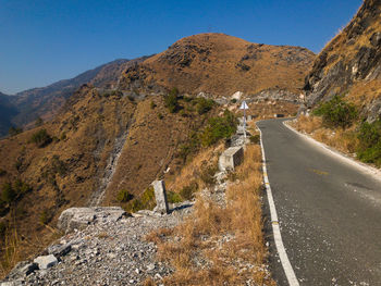 Road amidst mountains against clear sky