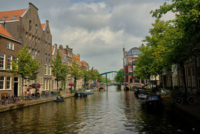 Canal amidst buildings in city against sky