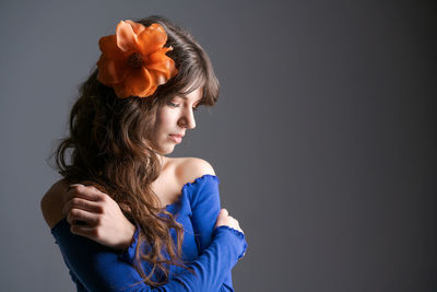 Portrait young woman with an artificial flower in her hair. natural beauty