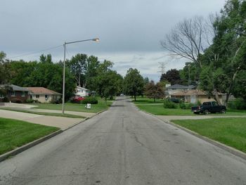 Empty road against cloudy sky