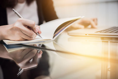 Midsection of woman reading book