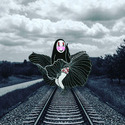 Digital composite image of woman with railroad tracks against sky