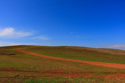 Scenic view of landscape against blue sky