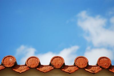 Low angle view of umbrellas against blue sky