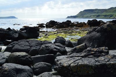 Rocks on beach against sky