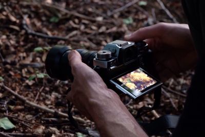 Cropped hands holding camera