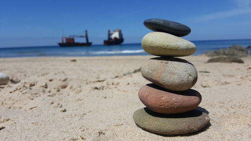 Stack of pebbles on sand at beach during summer