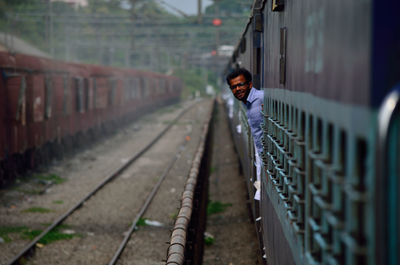 Portrait of smiling man leaning on train door