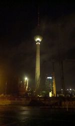 Low angle view of illuminated tower against sky at night